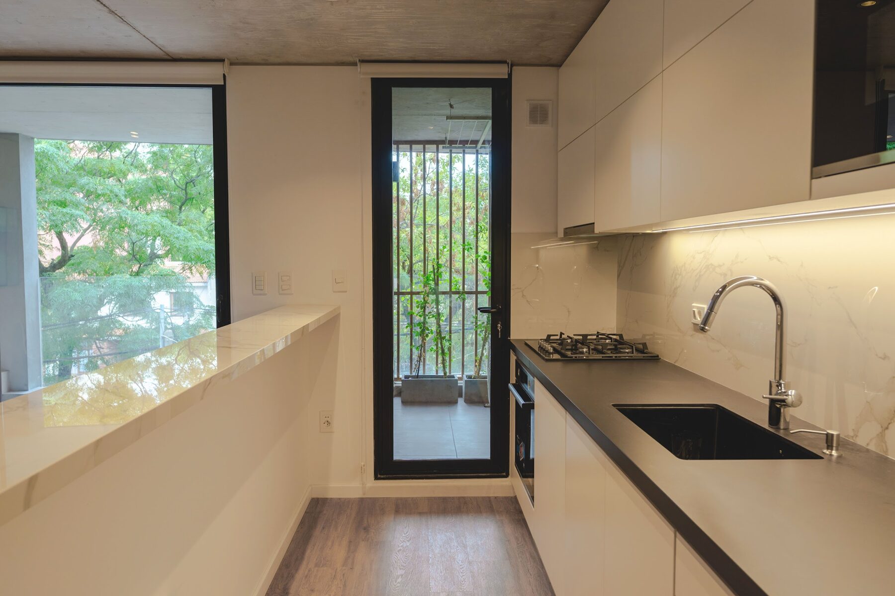 kitchen with a dark counter and a window onto the greenery