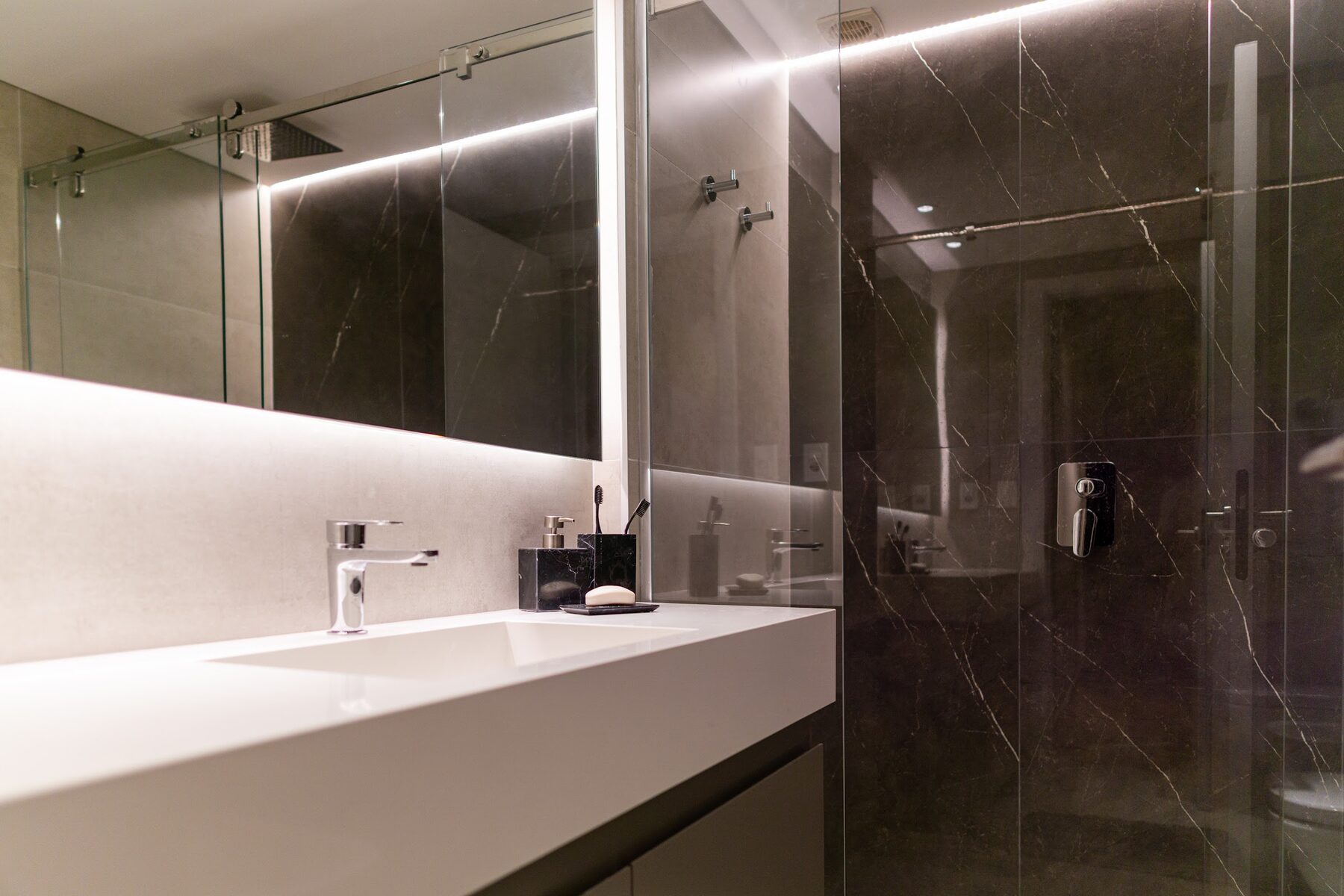 bathroom with a white counter and dark marble cladding