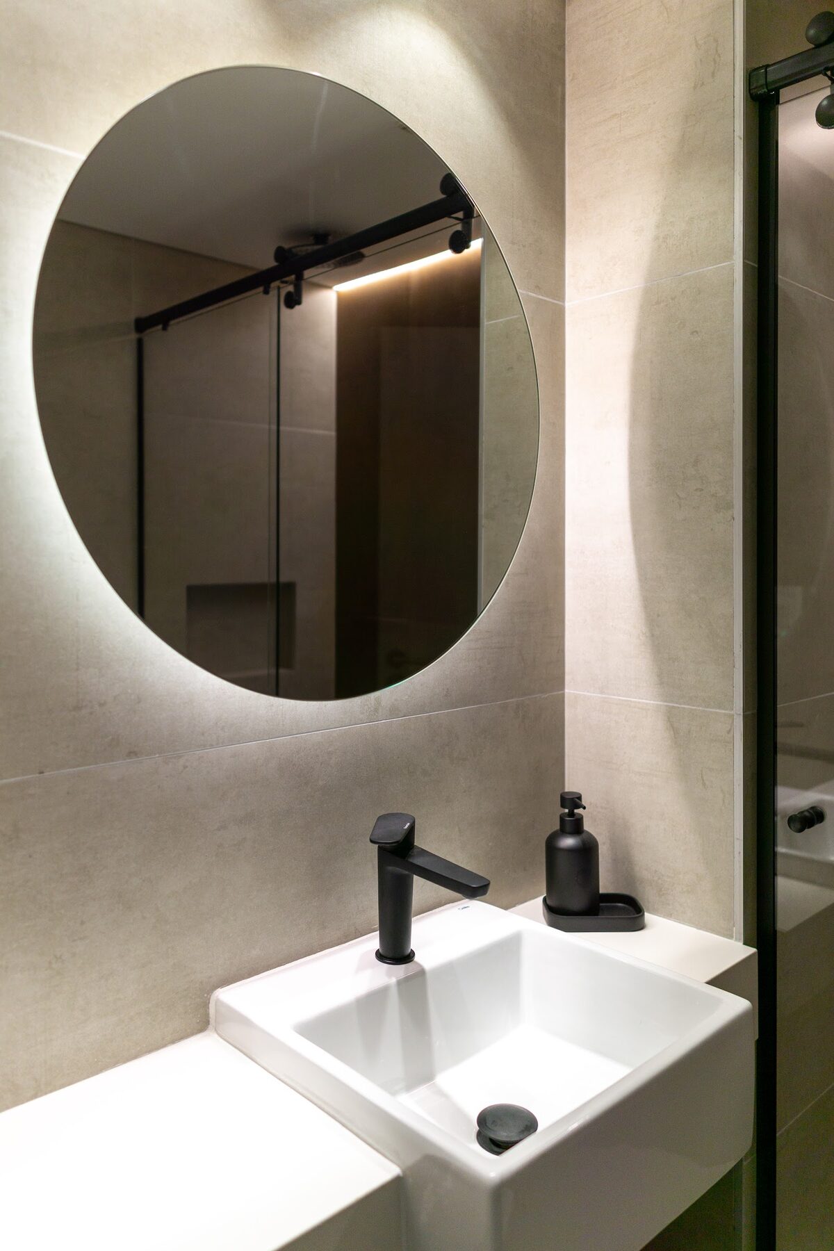 bathroom with a round mirror and a white basin