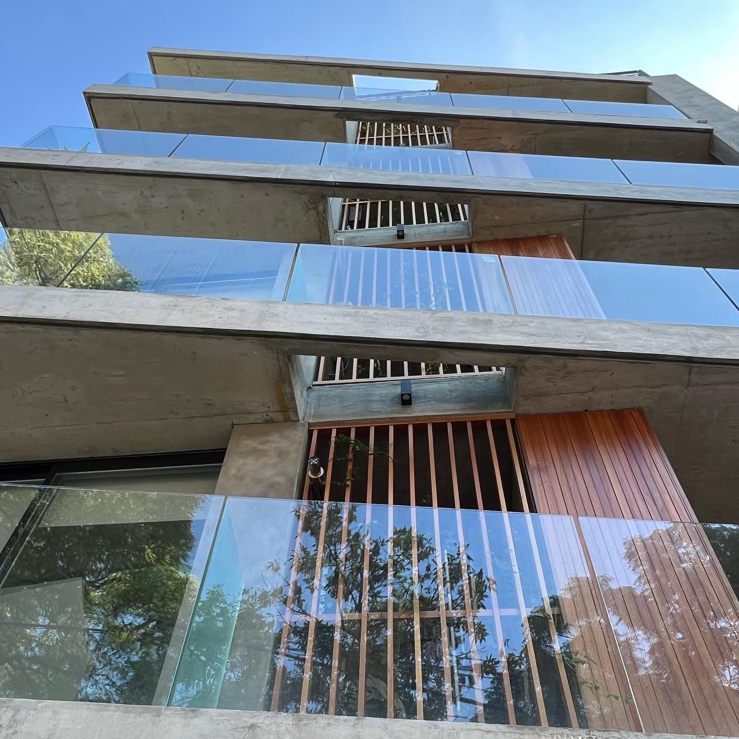 Edificio en Pocitos visto desde abajo: balcones de hormigón, vidrio y tamices de madera