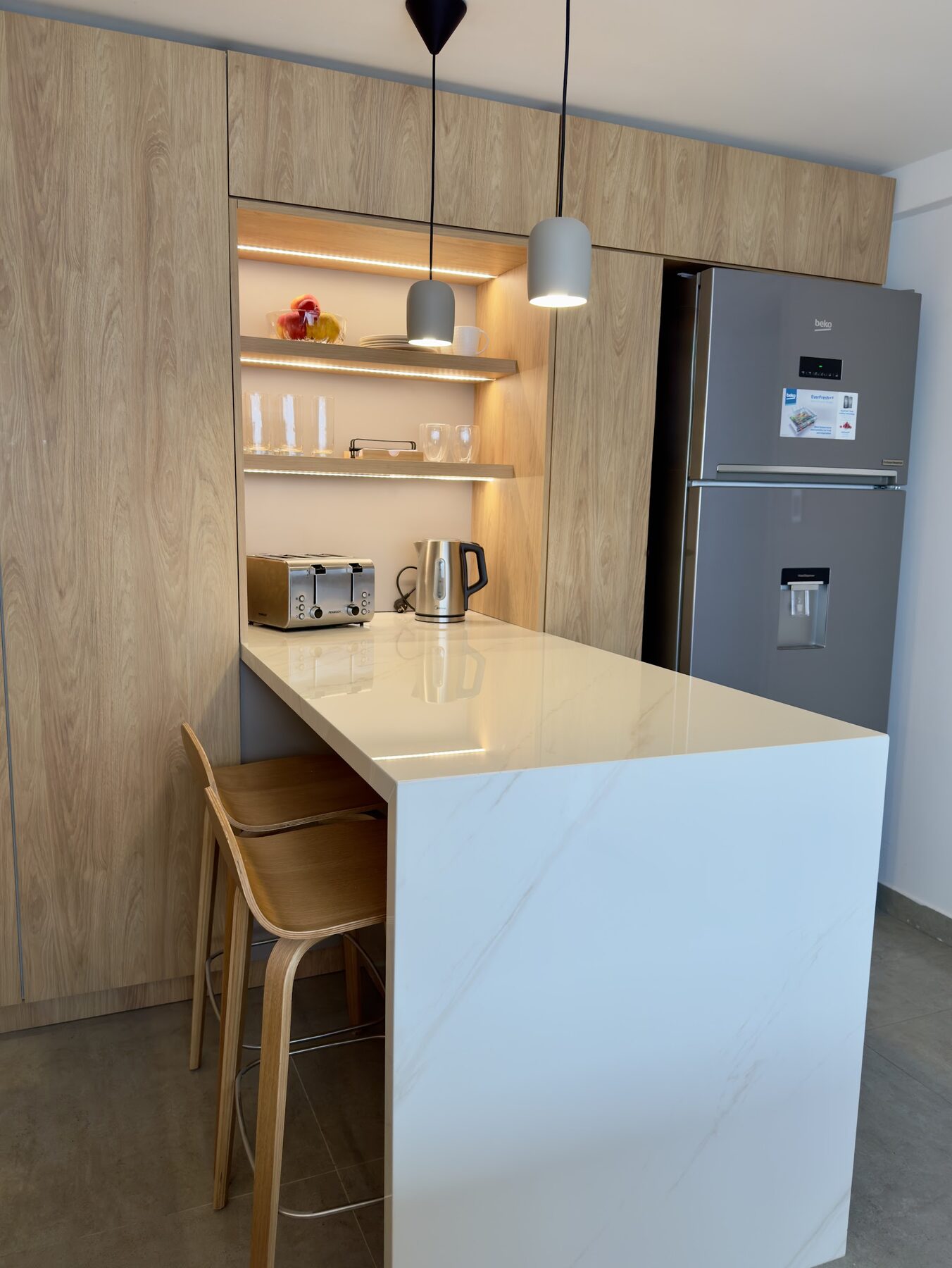 cocina con isla de mármol y muebles de roble
