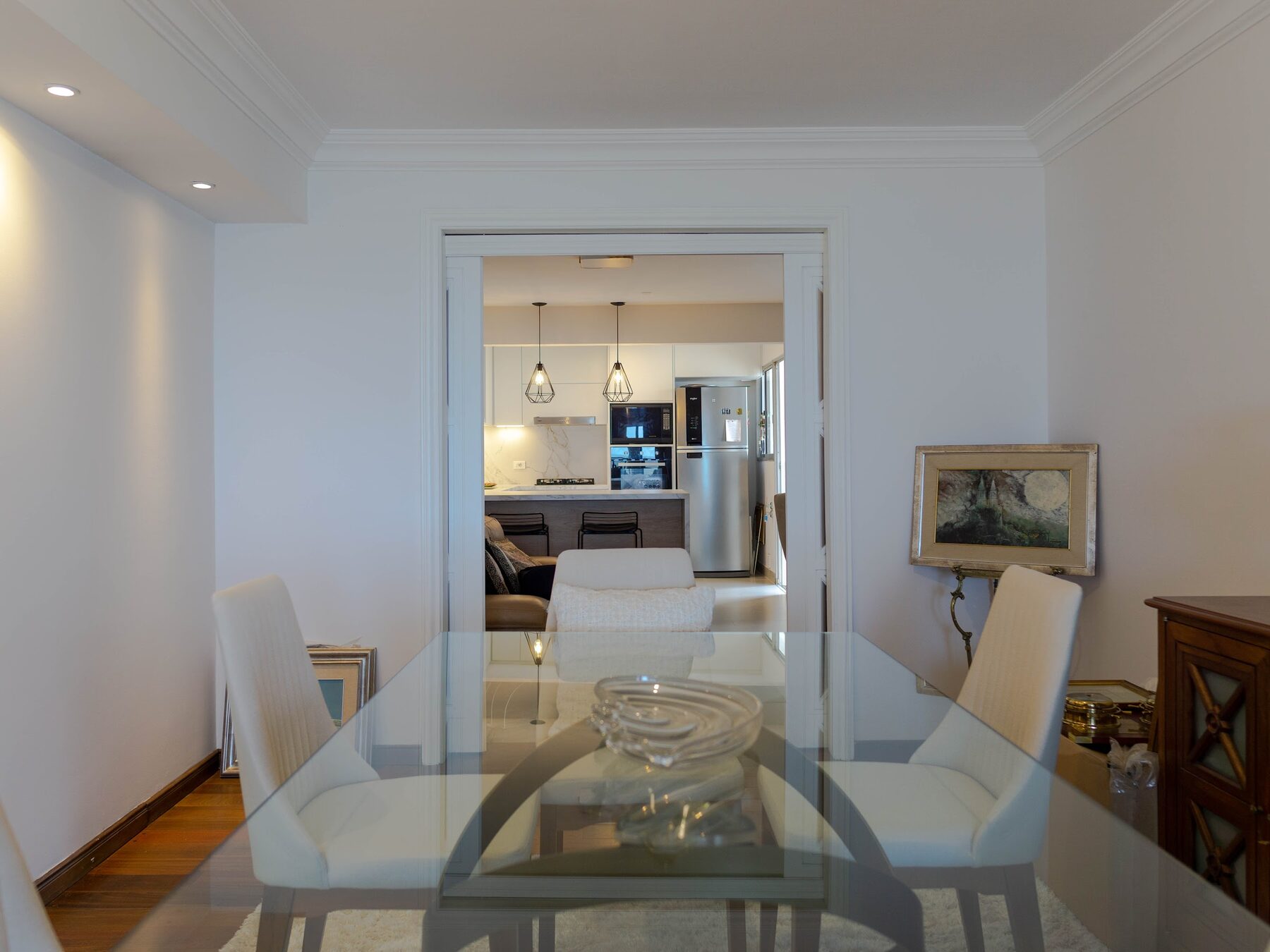 white kitchen with a marble counter and pendant lights